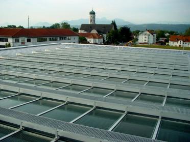 Dach der Aula mit Photovoltaik-Anlage (Kirchturm im Hintergrund)